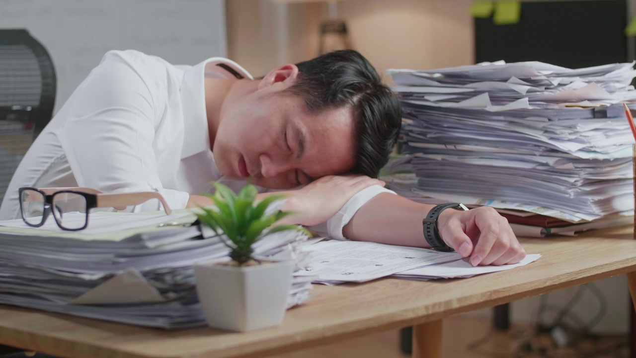 详情图-疲惫的亚洲人由于在办公室努力工作文件睡觉的特写