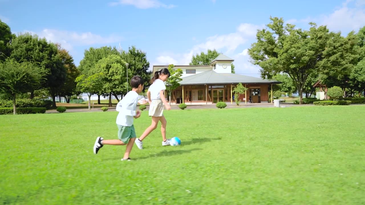 詳情圖-一個亞洲小孩在藍天公園里踢足球