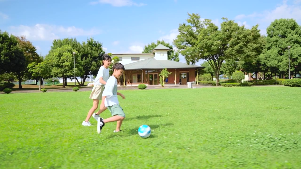 詳情圖-一個亞洲小孩在藍天公園里踢足球