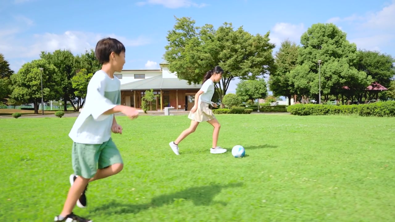 詳情圖-一個亞洲小孩在藍天公園里踢足球
