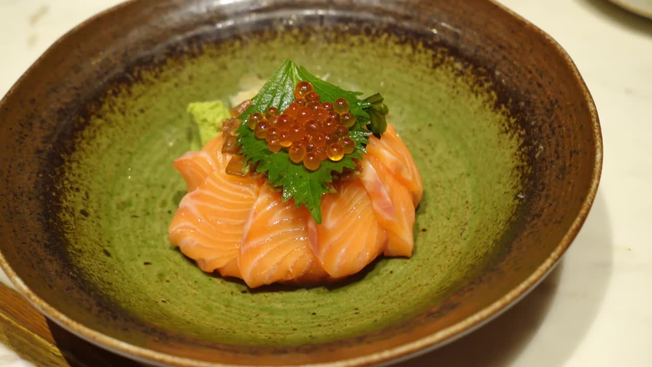 日本食物生三文鱼饭，上面有伊仓子。碗新鲜鲑鱼，红鱼子酱谷物和米饭。健康食品。豪华开胃菜在餐厅。准备为广告服务