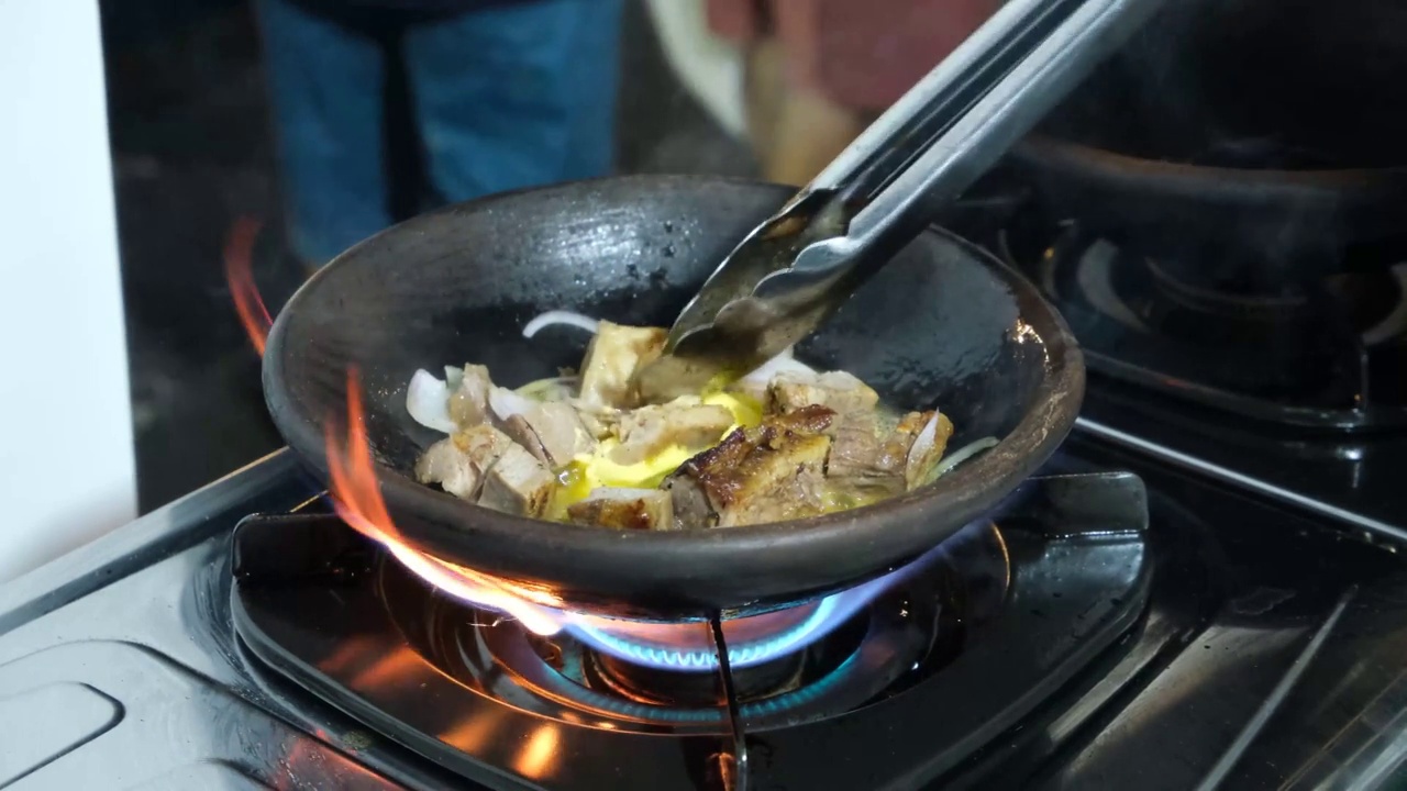 滋滋作响的烤香辣牛肉在砂锅上煮，印尼的流行菜肴