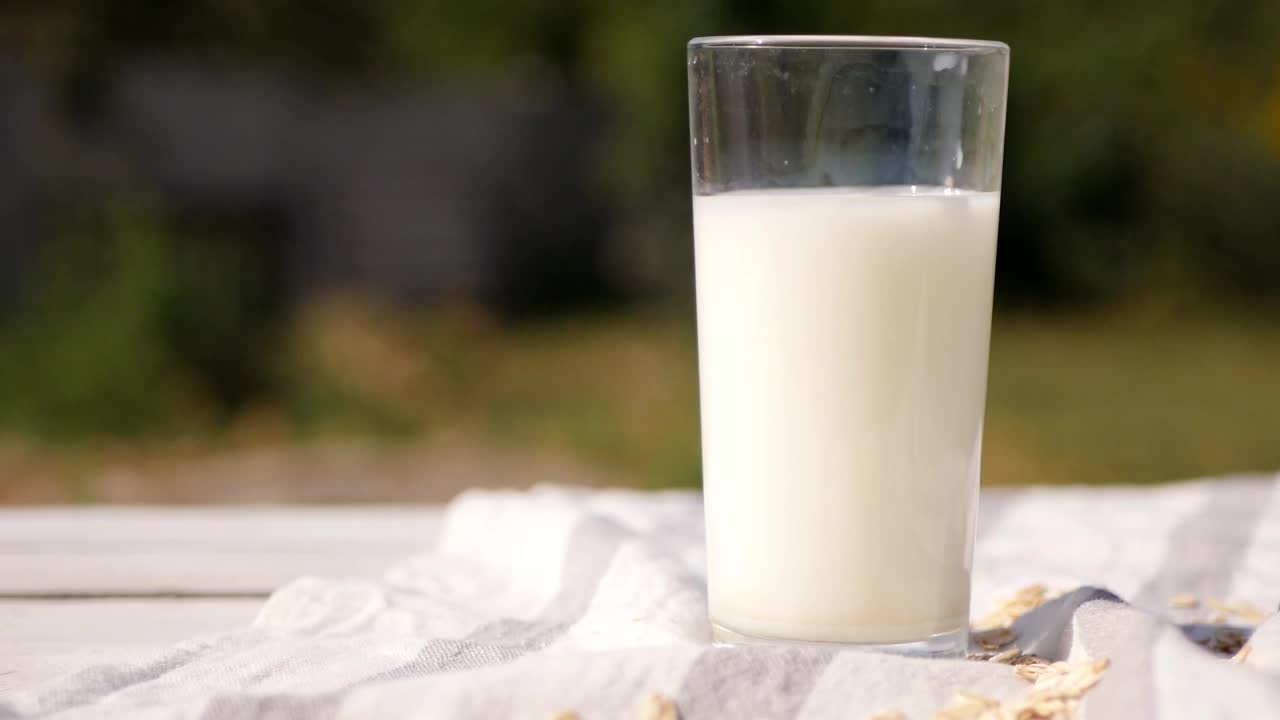 近距离的燕麦片落在一杯牛奶。