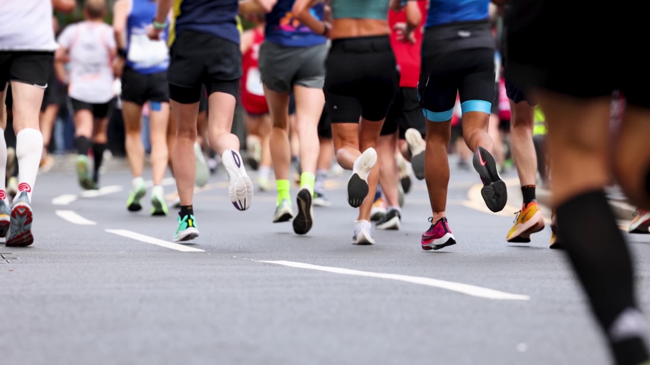 慢动作视角与浅焦点模糊城市马拉松运动员的腿