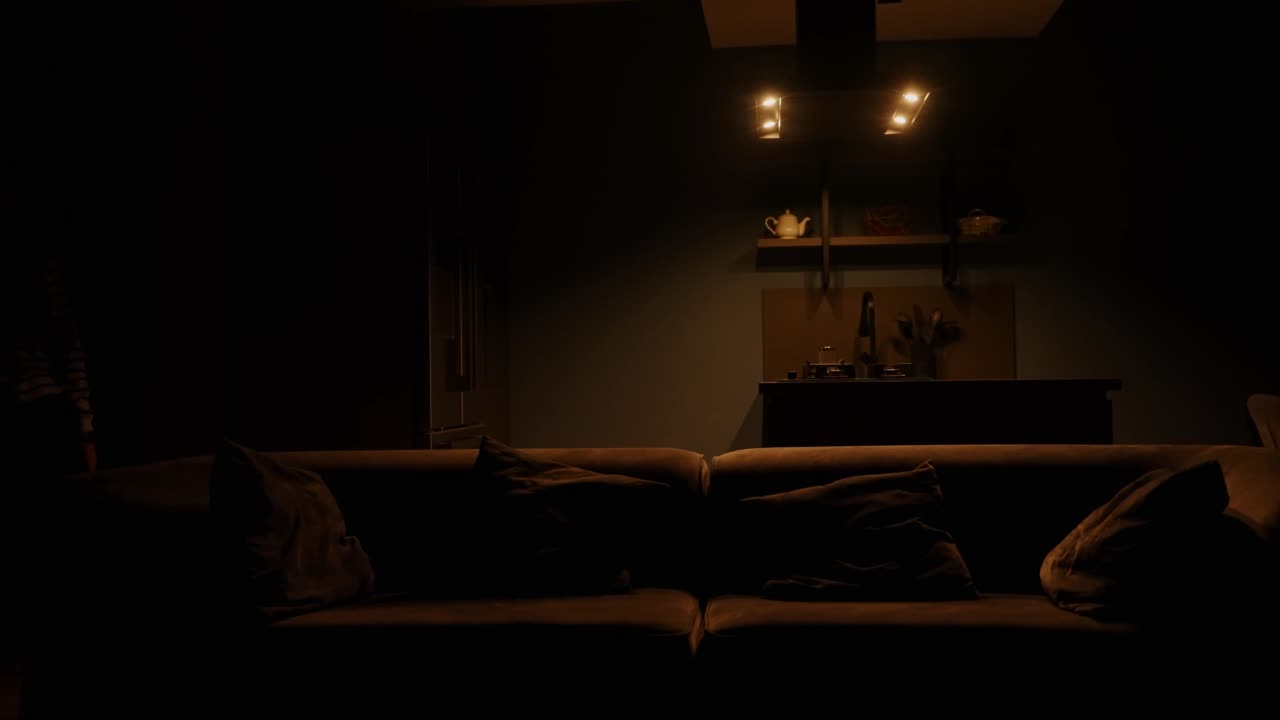 女士进入客厅，用智能家居物联网系统中的智能手表打开灯，坐在沙发上，用手表切换电视节目，在沙发上放松。现代住宅中的物联网。