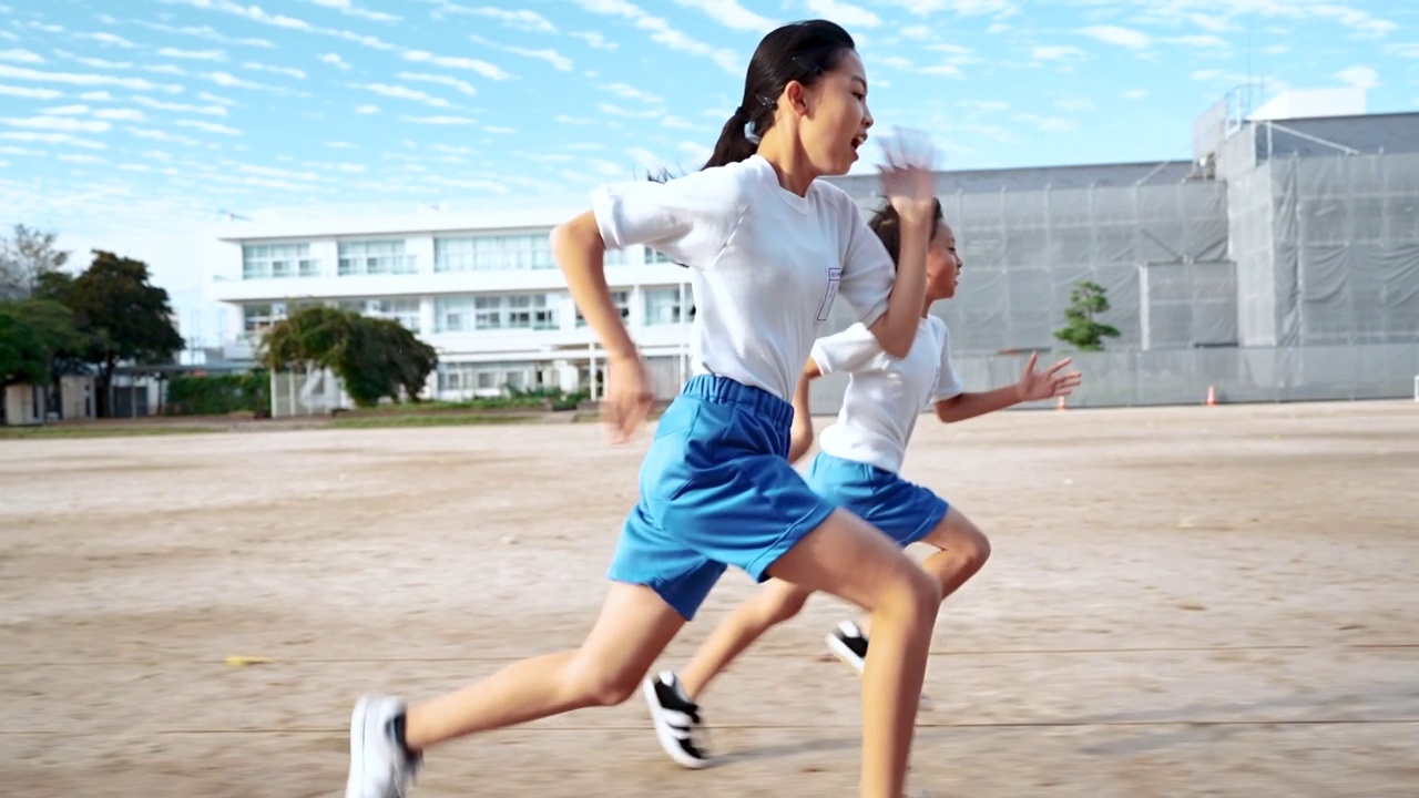 详情图-小学的男孩和女孩在学校操场上跑步