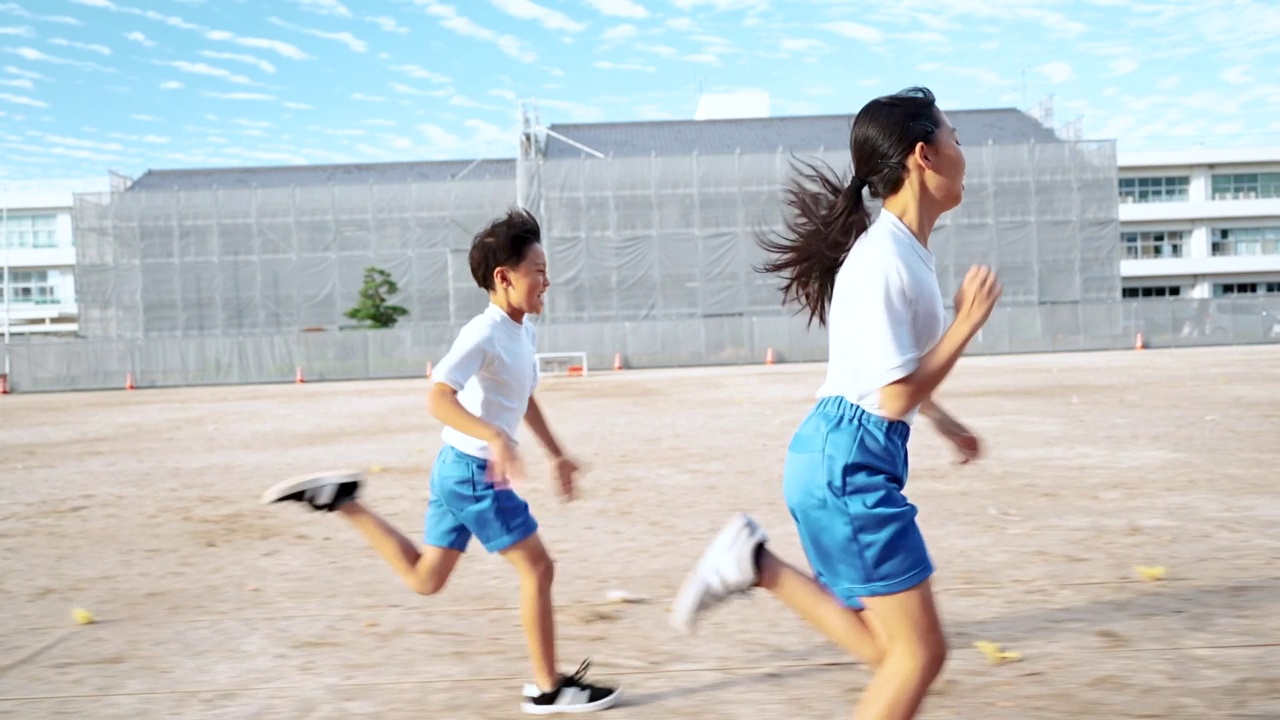 详情图-小学的男孩和女孩在学校操场上跑步