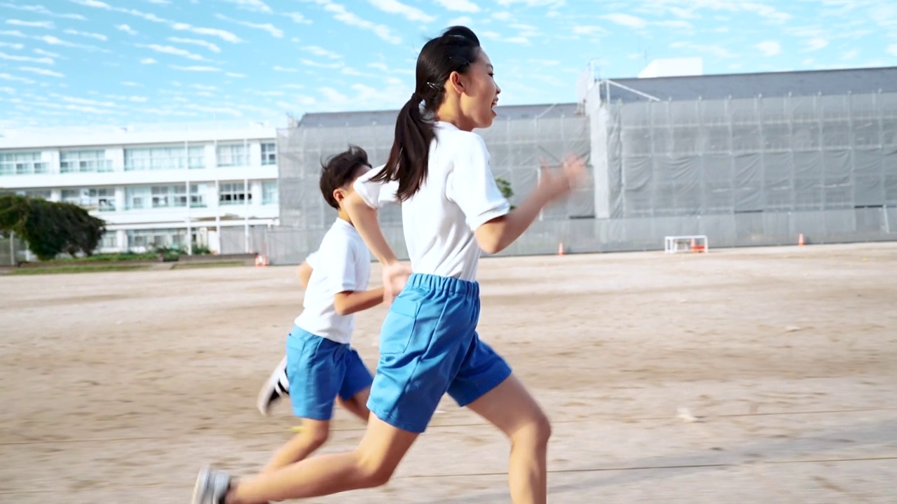 详情图-小学的男孩和女孩在学校操场上跑步