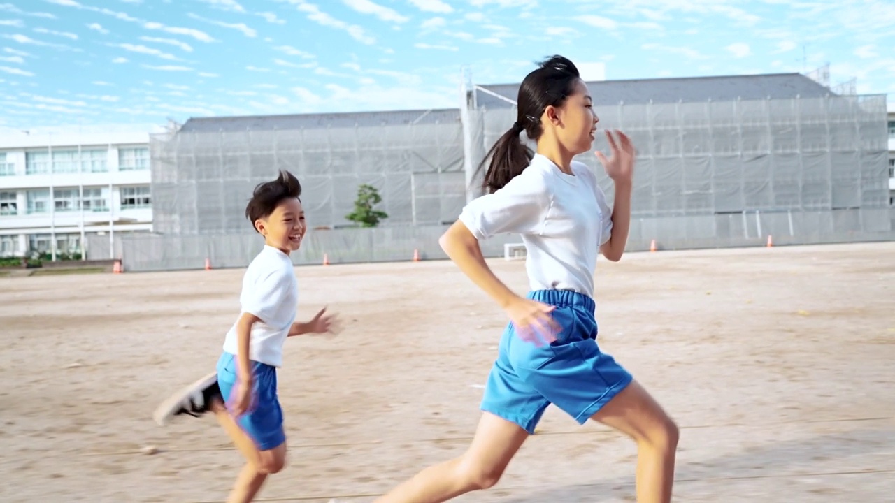 详情图-小学的男孩和女孩在学校操场上跑步