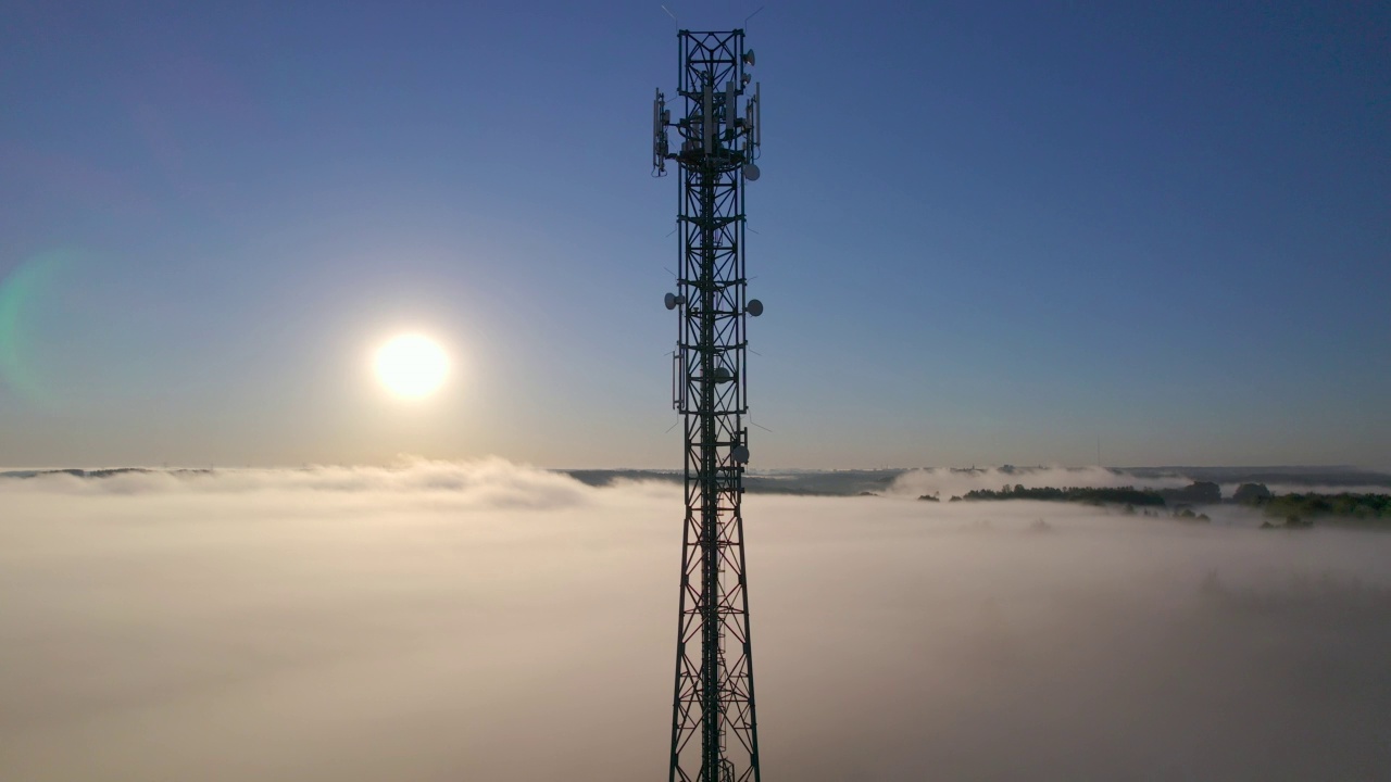 详情图-塔式天线电信手机鸟瞰图,蜂窝5g,4g手机无线电发射机。提供高速现代5g交通网络服务。日出时分的雾、云和天空