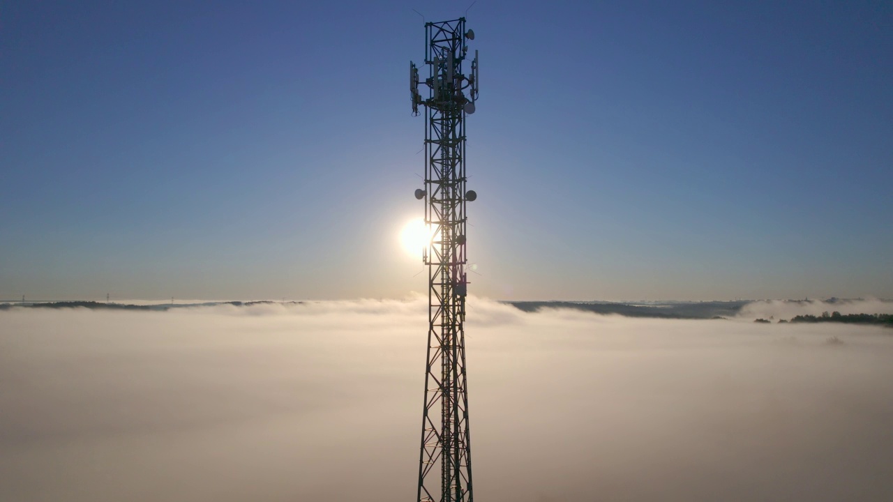 详情图-塔式天线电信手机鸟瞰图,蜂窝5g,4g手机无线电发射机。提供高速现代5g交通网络服务。日出时分的雾、云和天空