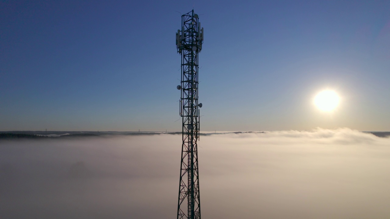 详情图-塔式天线电信手机鸟瞰图,蜂窝5g,4g手机无线电发射机。提供高速现代5g交通网络服务。日出时分的雾、云和天空