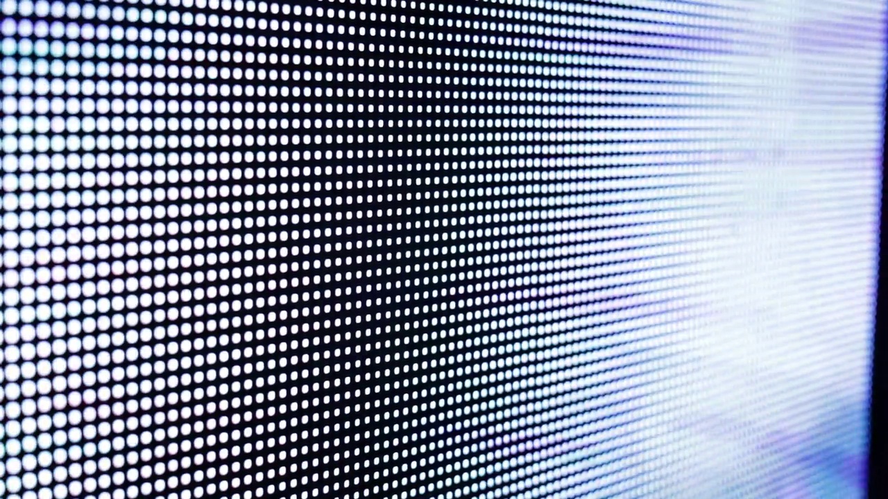 电视LED LSD屏幕在播放电视节目时的宏观视图。彩色RGB像素在接近时创建抽象图案。数字故障效应。故障VHS噪音。