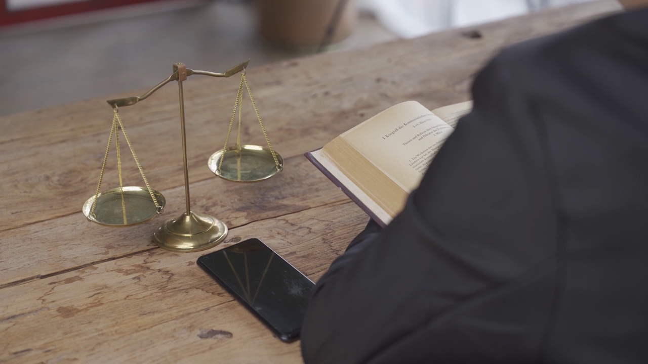 律师事务所有在线法律咨询和法律咨询的概念。律师法官坐在桌子上，拿着纸质智能手机和锤子金色的正义鳞片4K