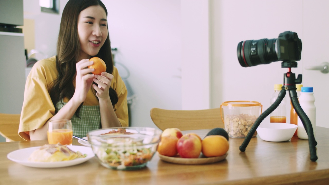 詳情圖-女博主網(wǎng)紅在家里廚房做飯的時(shí)候，直播和錄制沙拉水果和蔬菜的視頻。社交媒體影響者的概念。