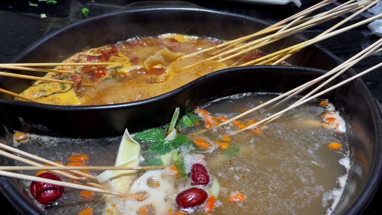 用筷子煮重庆火锅汤的特写镜头