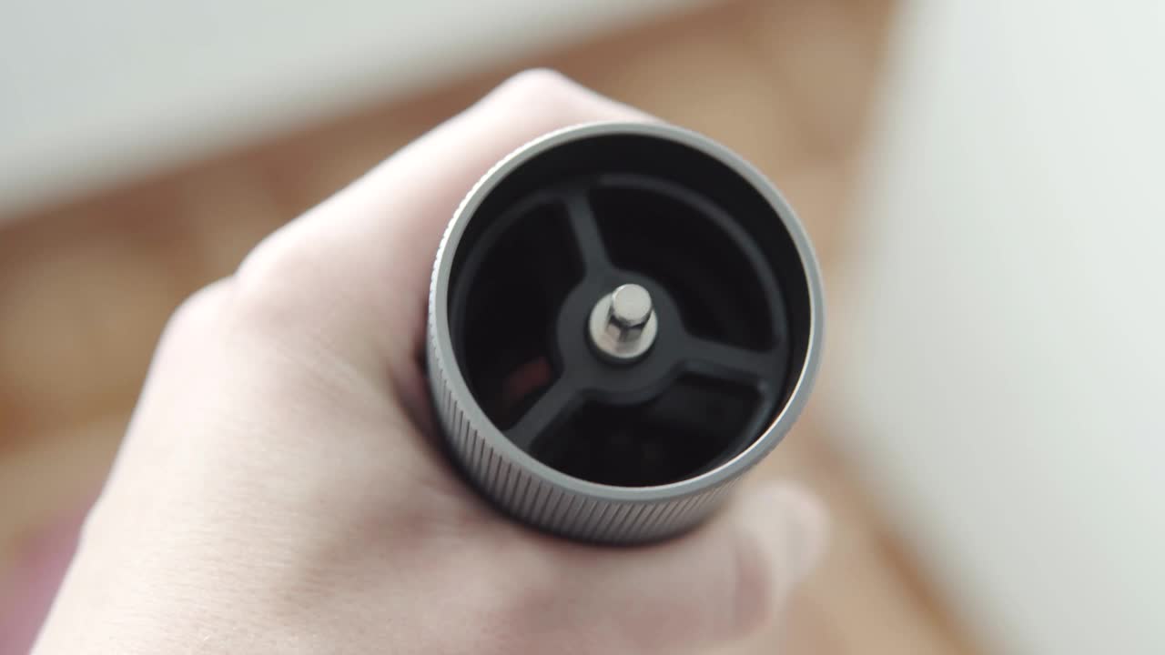 一名男子将刚烘焙好的优质咖啡豆装入咖啡研磨机。