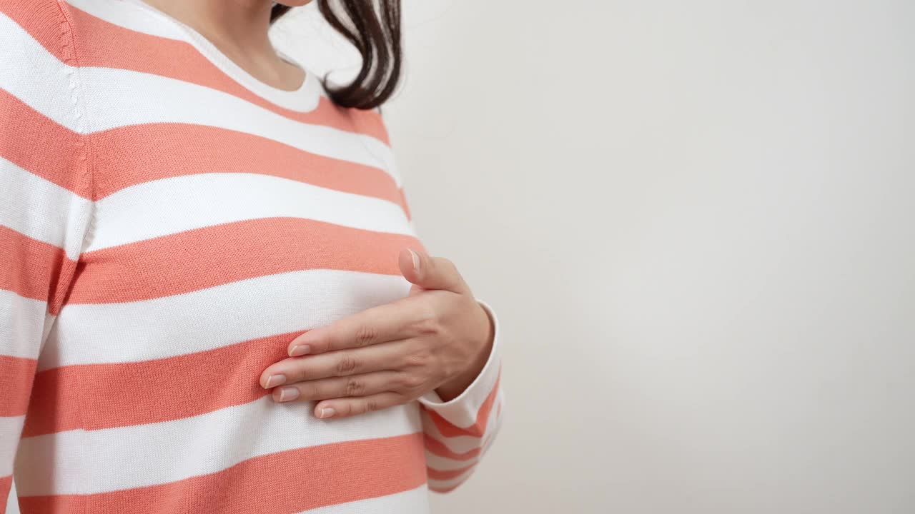 乳腺癌，世界癌症日。年轻的亚洲妇女检查，触诊乳房肿块或癌症。