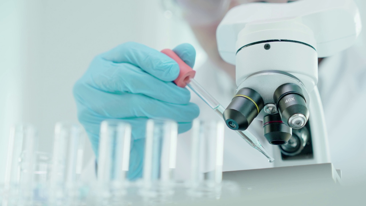 男科学家在先进的科学实验室分析生化样品。医学专业人员用显微镜观察病毒的微生物发育。实验室生物技术研究。