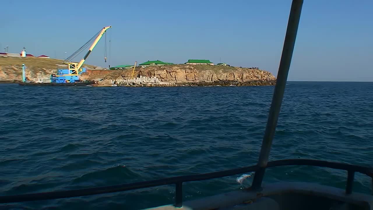 从一艘沿着海岸缓慢移动的船上看蛇岛。