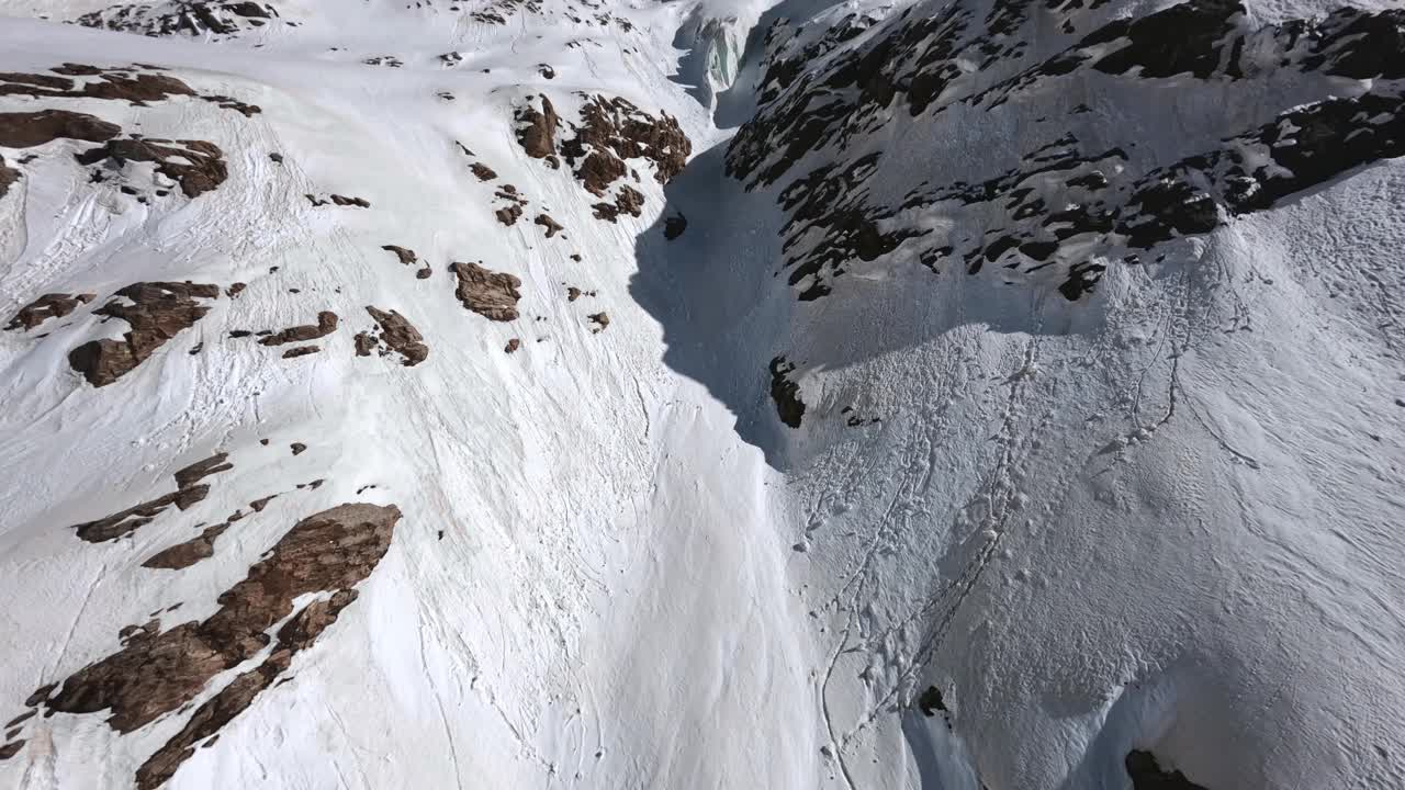 高山峡谷阳光明媚的景观冰川滑雪者之间的悬崖准备自由骑行下坡鸟瞰图