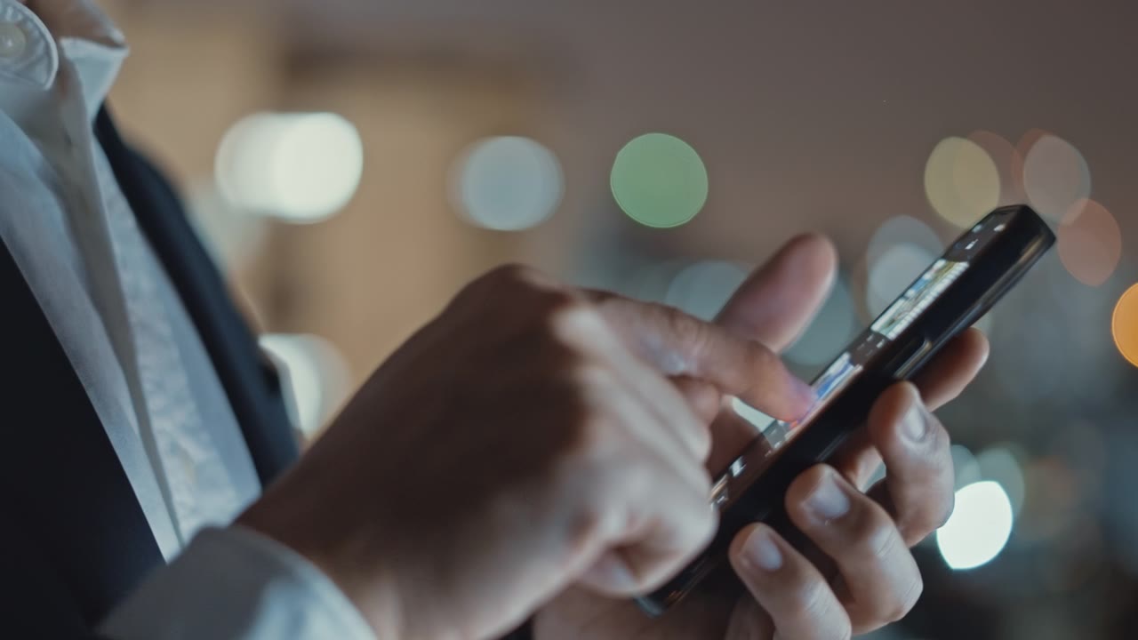 详情图-商人在晚上使用智能手机，特写