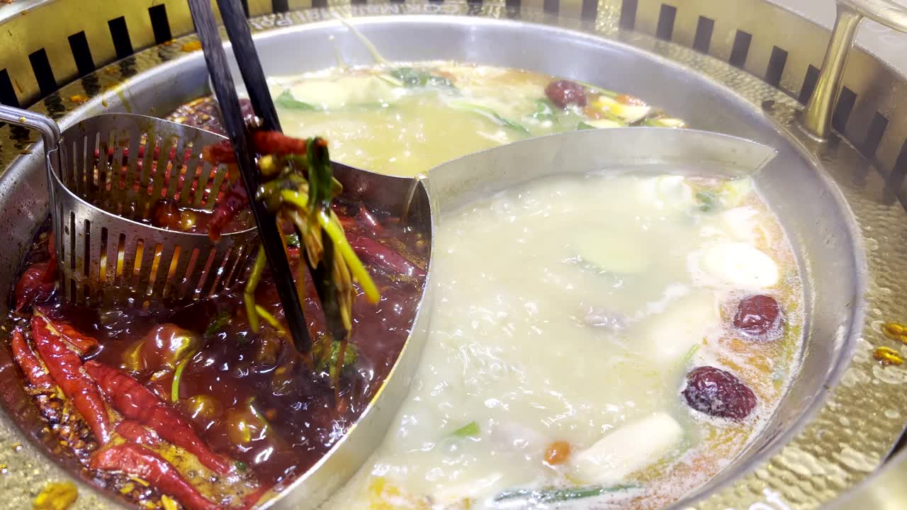 把筷子和牛肉蘸在煮沸的汤里