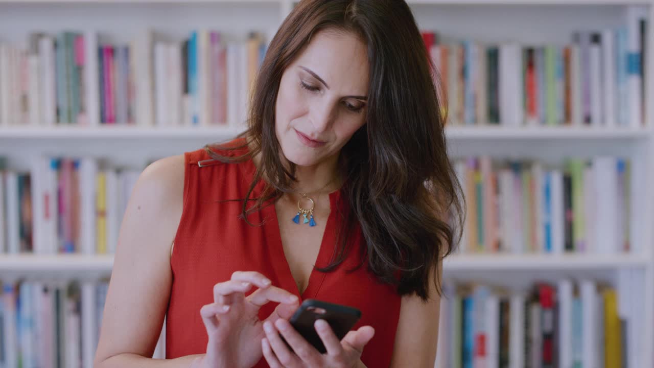 电话，社交媒体，和一个在图书馆里笑着打短信的女人交流。移动，联系和网络与一个快乐的女图书管理员发短信在书店里开玩笑