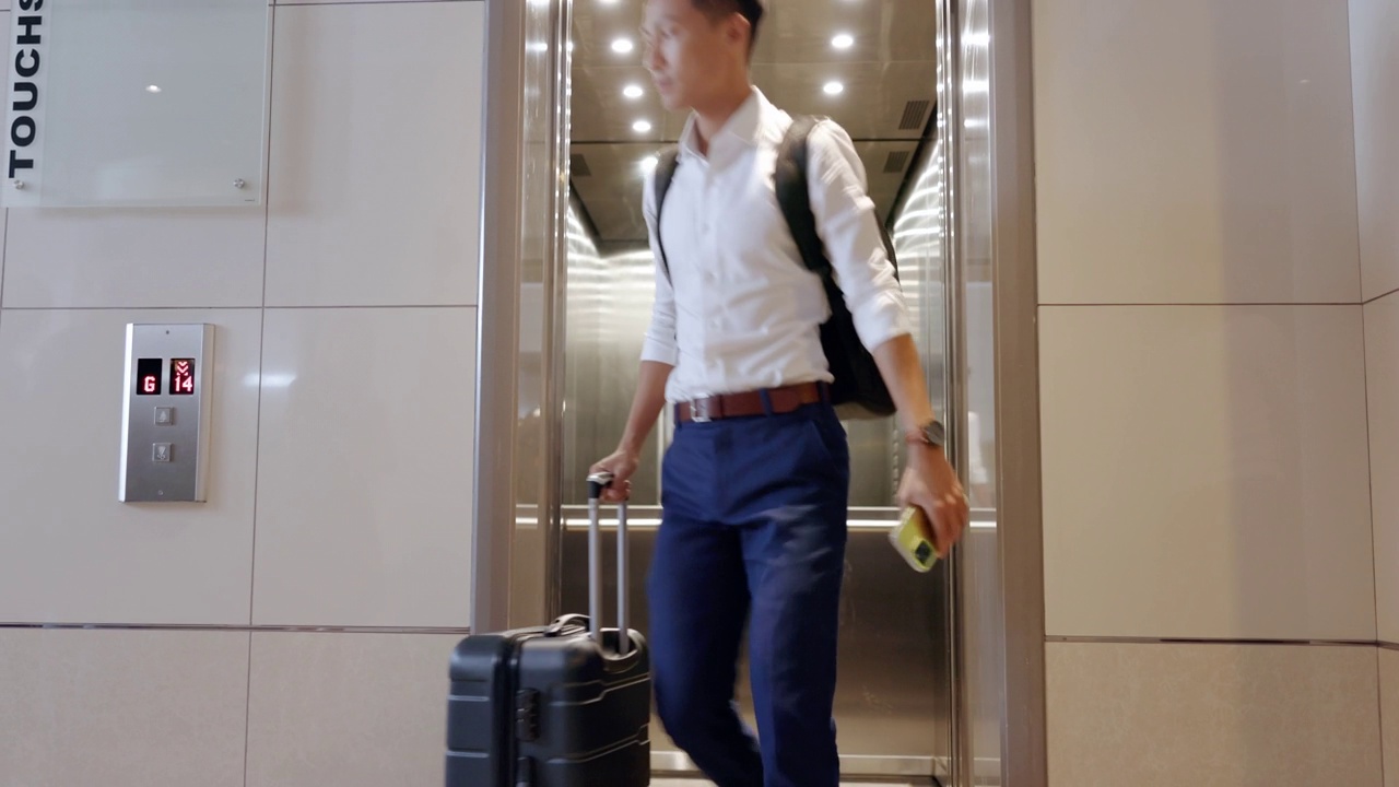 详情图-电梯，旅行，和一个商务亚洲人在机场，检查他的航班起飞的时间。门，地板和迟到的一个男性员工在旅行时提着行李箱