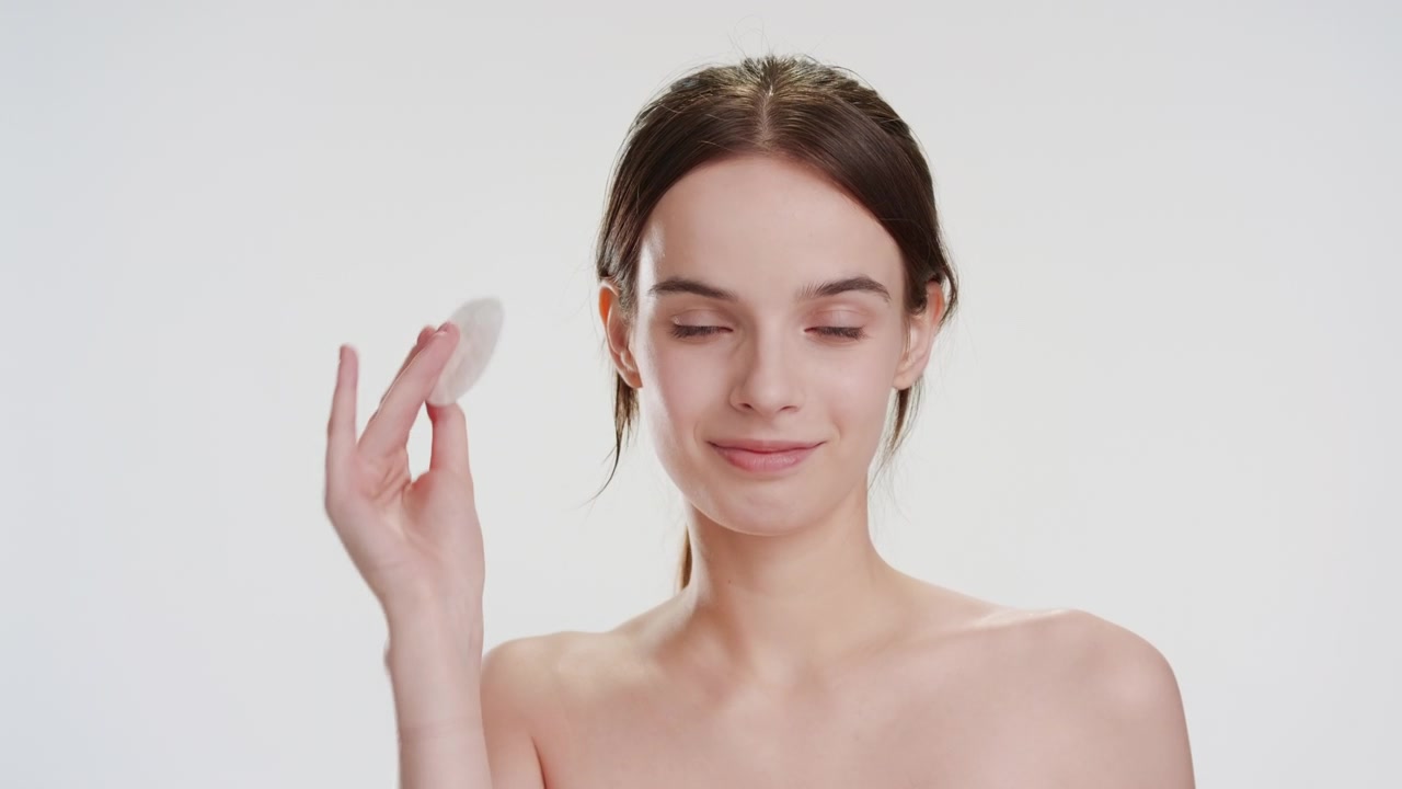 详情图-美丽的白人女子微笑着用化妆棉抚摸脸