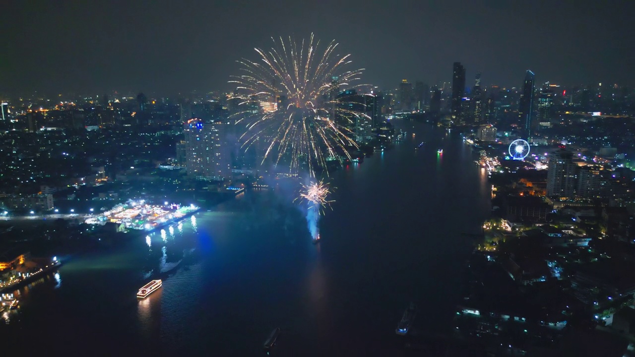 空中无人机视角多色烟花表演在天空之城。除夕。摩天大楼和城市景观庆祝夜晚的灯光
