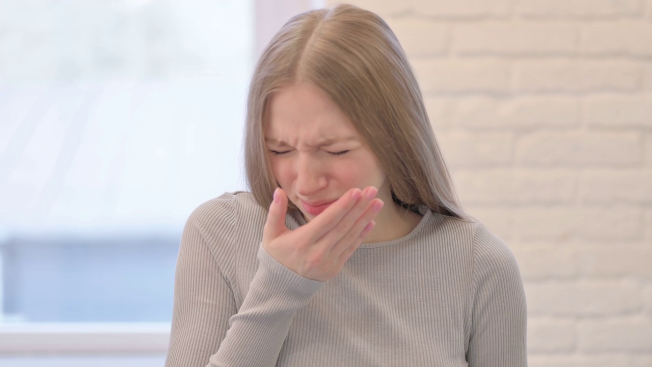 生病的年轻女子咳嗽