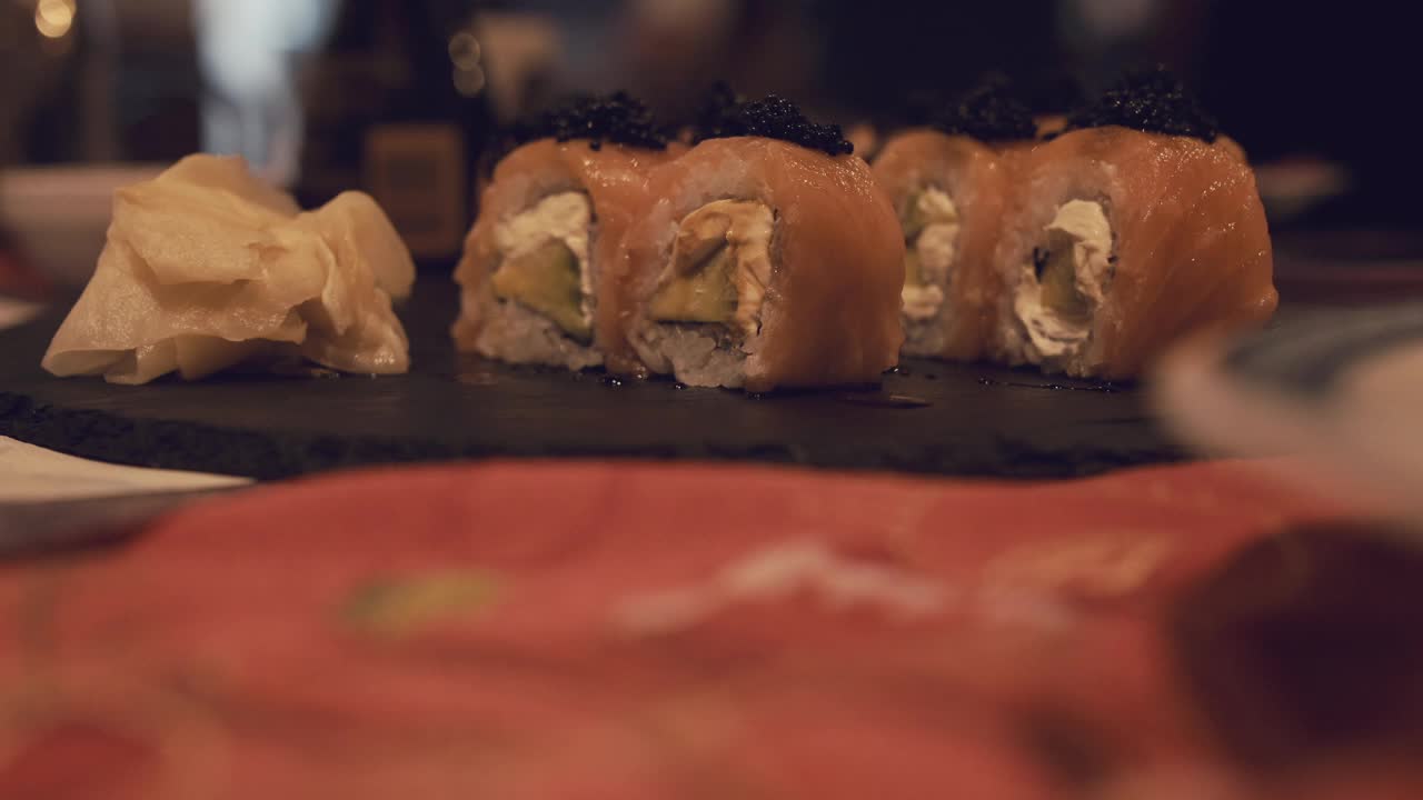 一位顾客在餐厅用筷子拿寿司