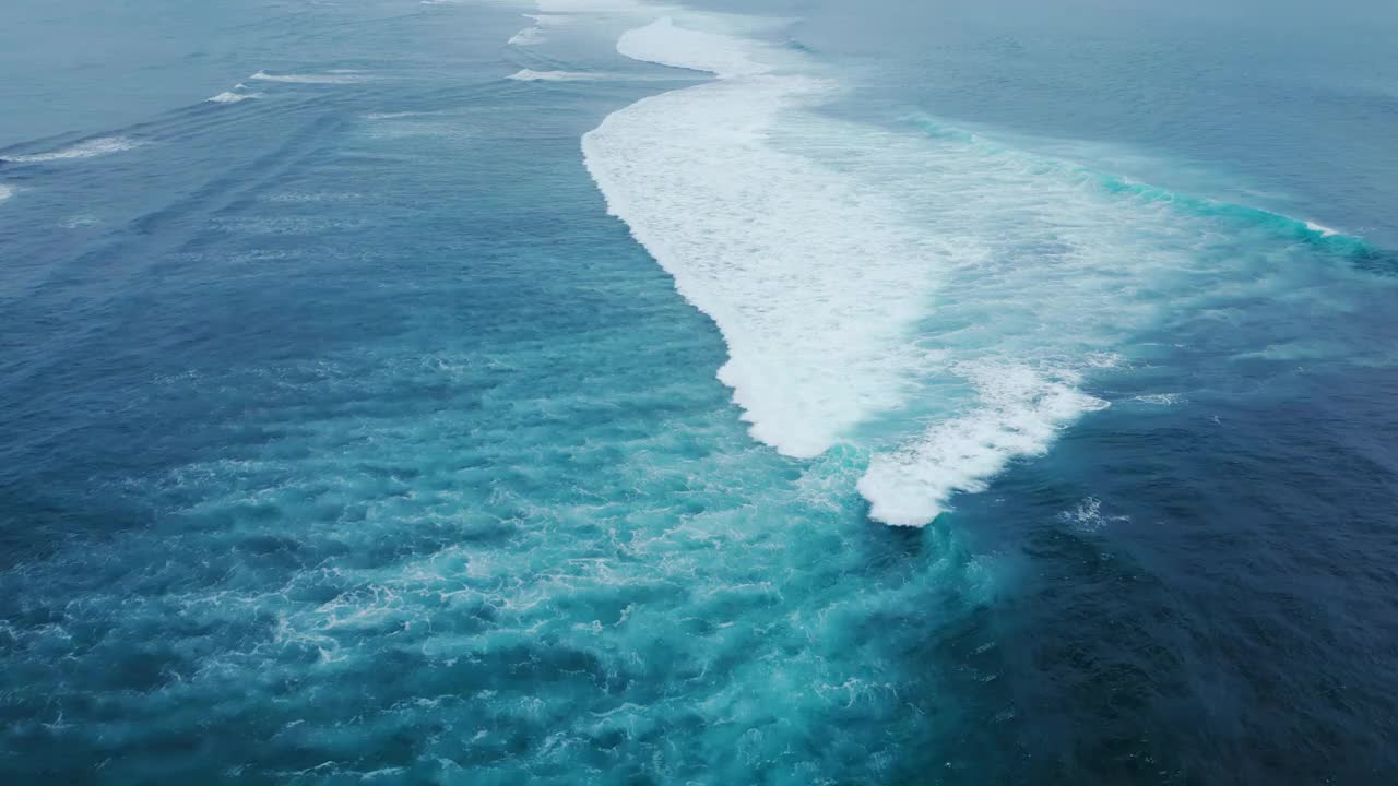 碧海碧波碧水。鸟瞰海浪与白色大卷曲。电影的流动高膨胀。上方自然水旋风日。op Shot抽象海洋景观背景