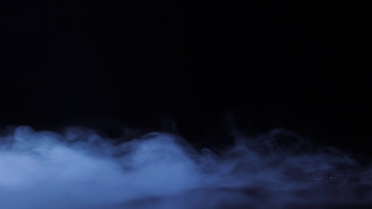 來(lái)自液氮的蒸汽沿著平坦黑暗的表面爬行。地面上濃煙滾滾。漂亮的抽象背景