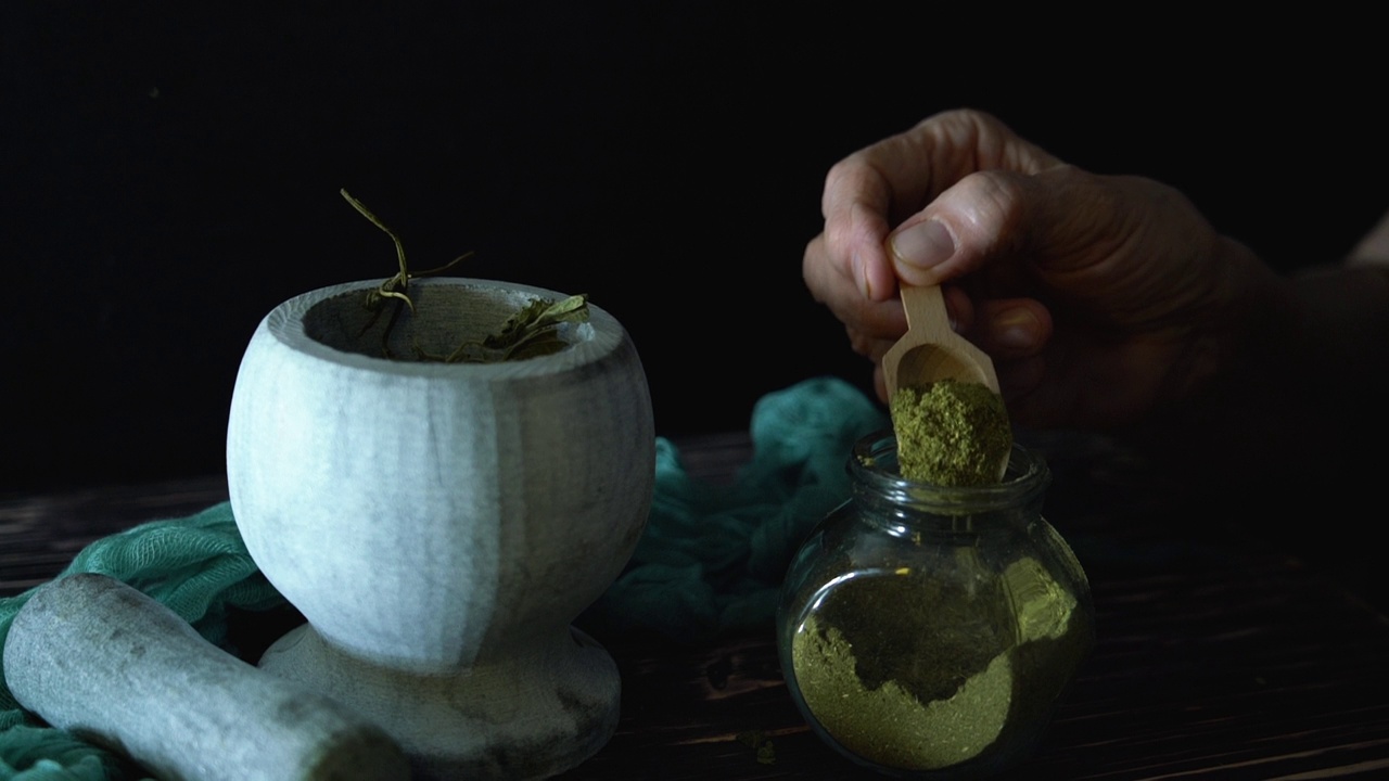详情图-草药医生把草药洒在地上。草药的制备。