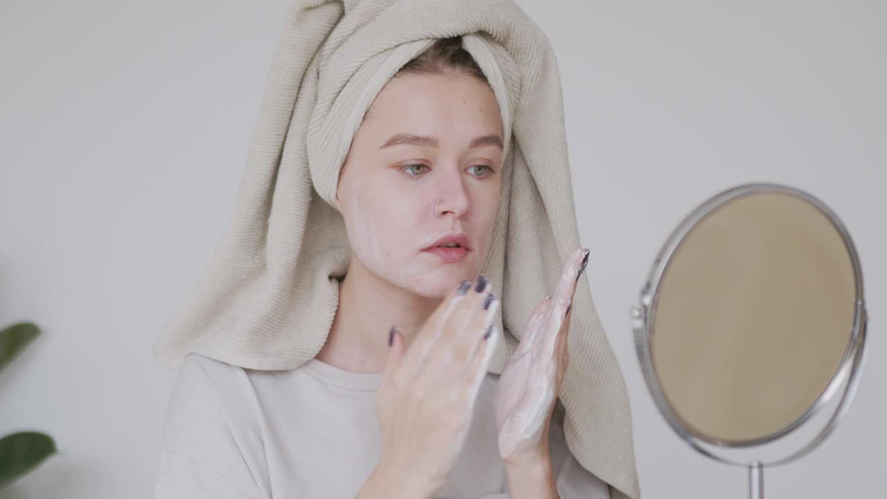 女士正在用有机泡沫肥皂洗面奶洗脸。女孩正在清洁面部皮肤，做按摩动作。美容程序，水疗，健康和健康的皮肤护理理念。