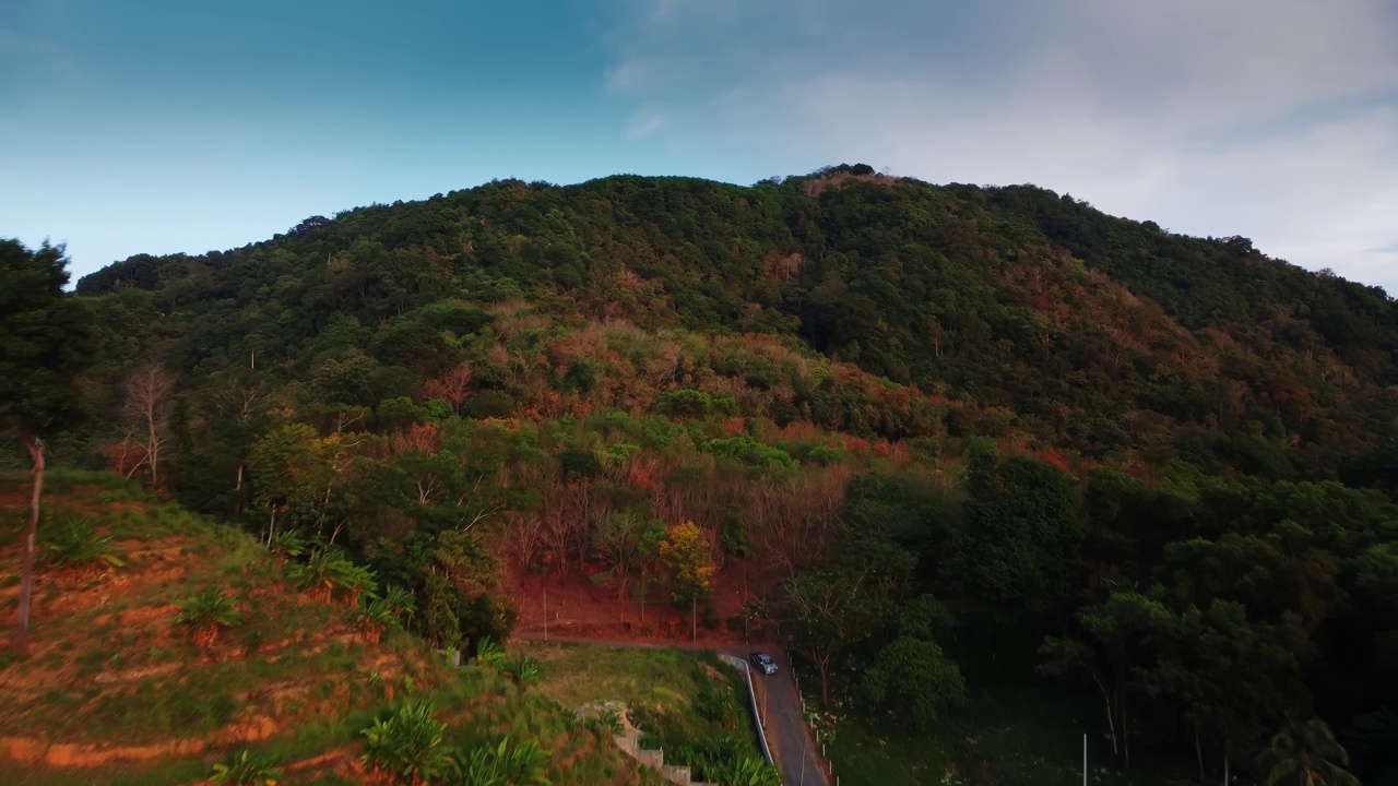 丛林覆盖的绿色山脊景观和附近的柏油路