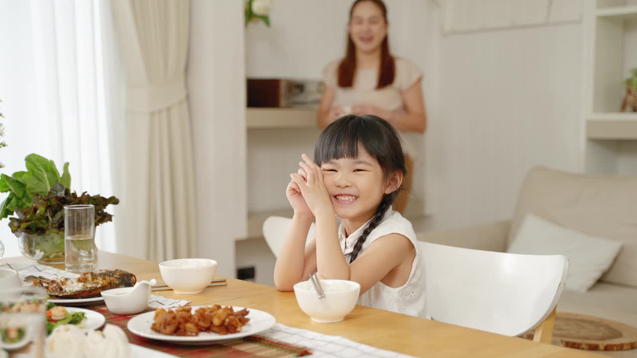 母亲在早餐时给女儿端上牛奶，家庭关系概念，健康食品