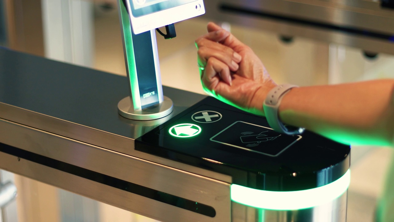 一名女员工用手腕上的智能手表扫描门禁打开门。