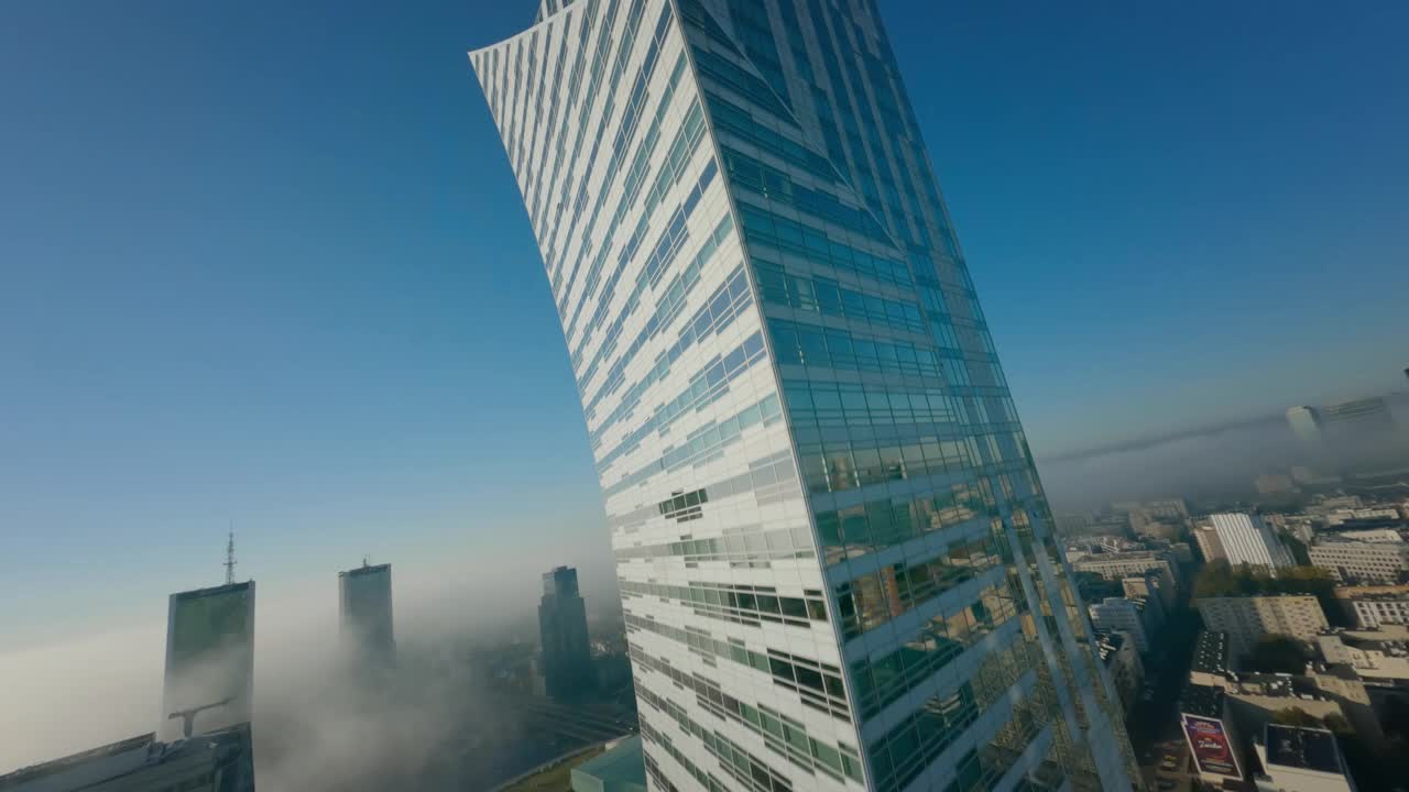 第一人称无人机飞行观看阳光明媚的城市景观在白天与高大的玻璃摩天大楼