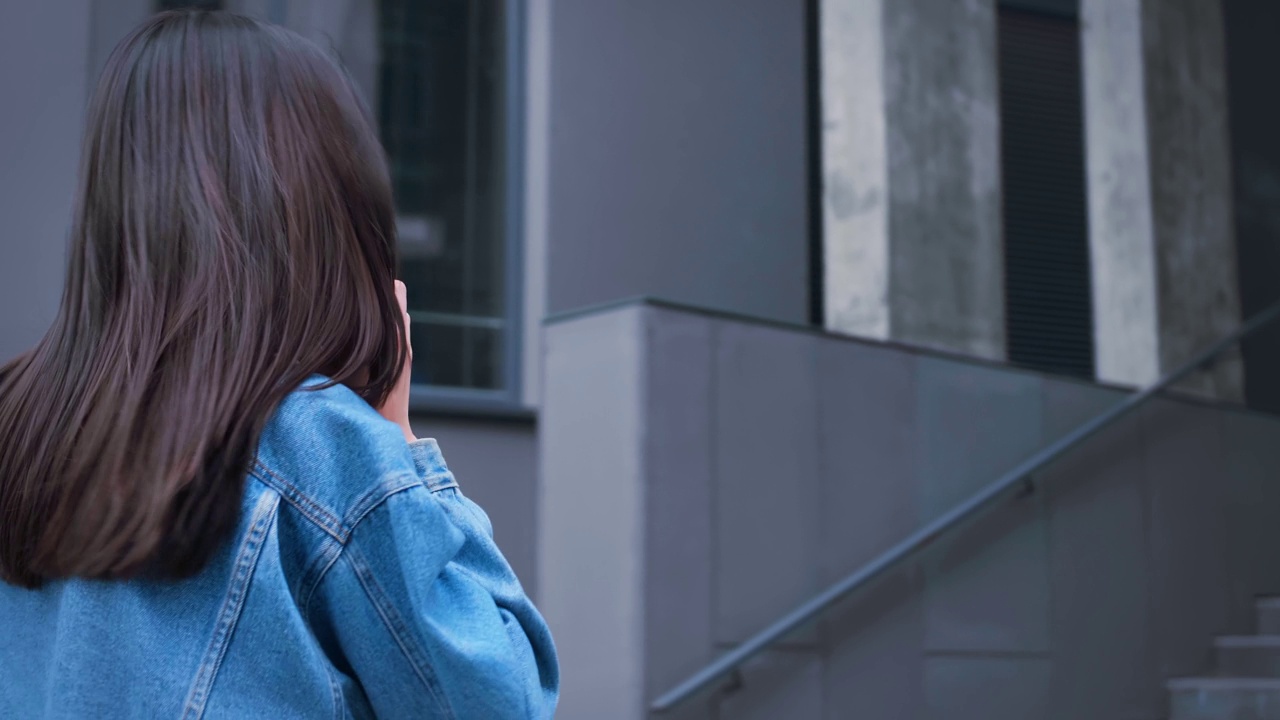 背后的女人女商人走在商业公司或购物中心讲手机通信在线远讲用智能手机接听电话背后的女孩