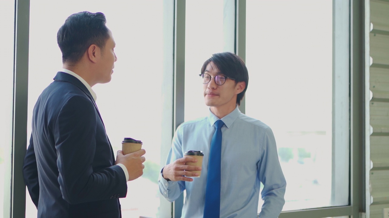 两个亚洲同事在办公室谈话。