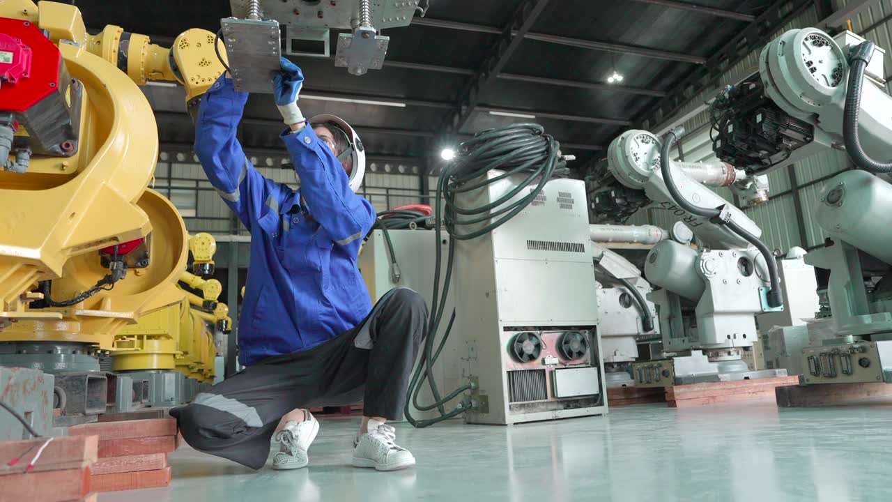 详情图-工业工厂的安全。工伤事故。生产线工人在工作时发生事故或昏倒，在工厂检查机械臂的工作系统，同事过来帮她急救。
