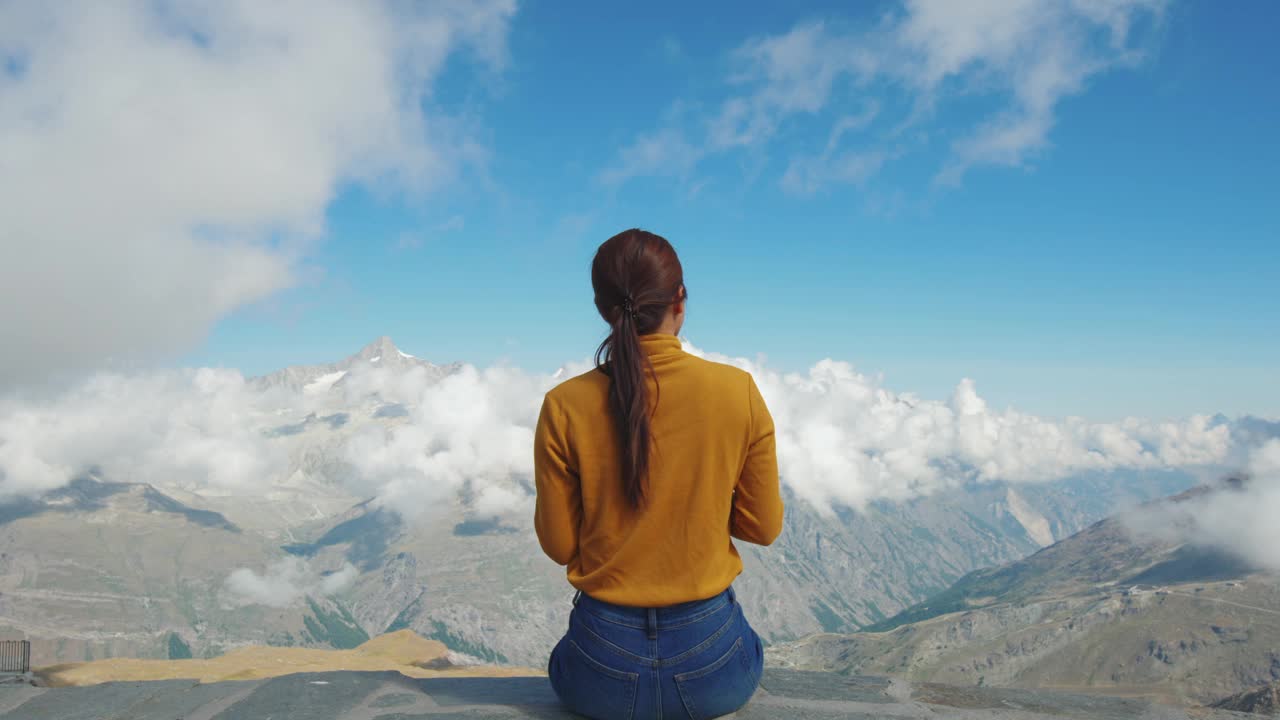 一名妇女在山顶用手机拍照