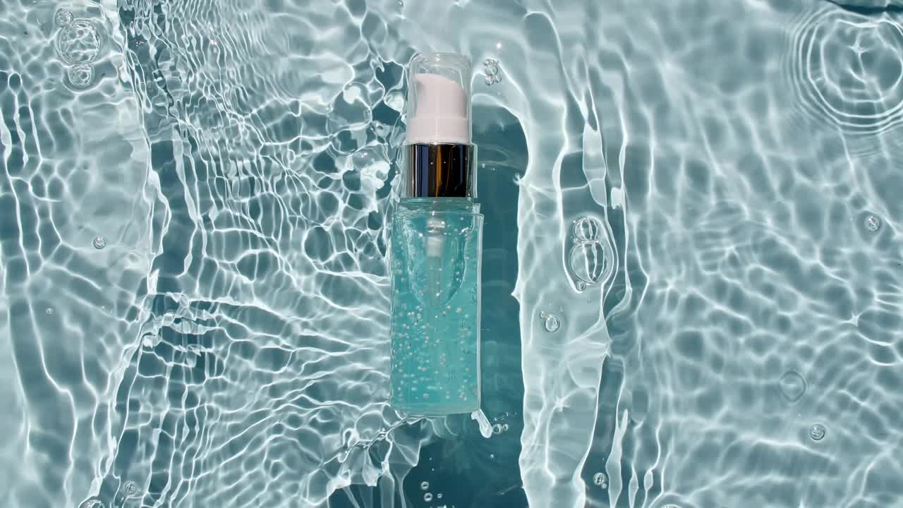 美容spa。瓶装的精华液，胶束爽肤水和乳液在水纹理背景与飞溅。医疗护肤。包装设计的视频，化妆品的广告。
