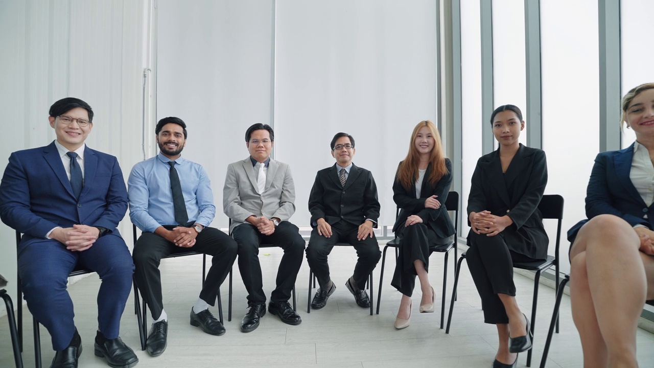 詳情圖-一群不同的公司同事一起坐在現(xiàn)代辦公室里。成功的公司與商業(yè)團(tuán)體的人微笑著看著鏡頭。商業(yè)專業(yè)人士的混合年齡組