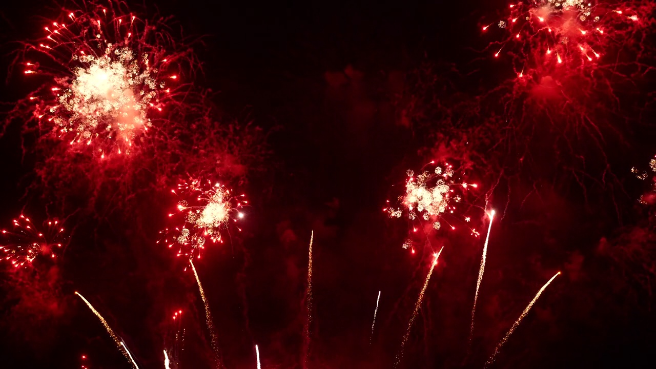 红色的烟花在晚上庆祝周年纪念，庆祝国庆节。2024年新年快乐，7月4日节日快乐。红色烟花倒计时2024年春节联欢会时间活动