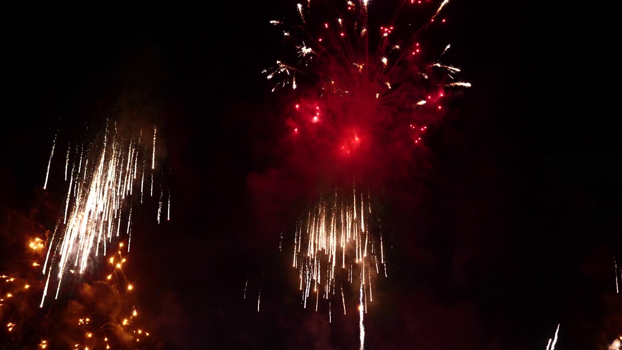 详情图-红色的烟花在晚上庆祝周年纪念，庆祝国庆节。2024年新年快乐，7月4日节日快乐。红色烟花倒计时2024年春节联欢会时间活动