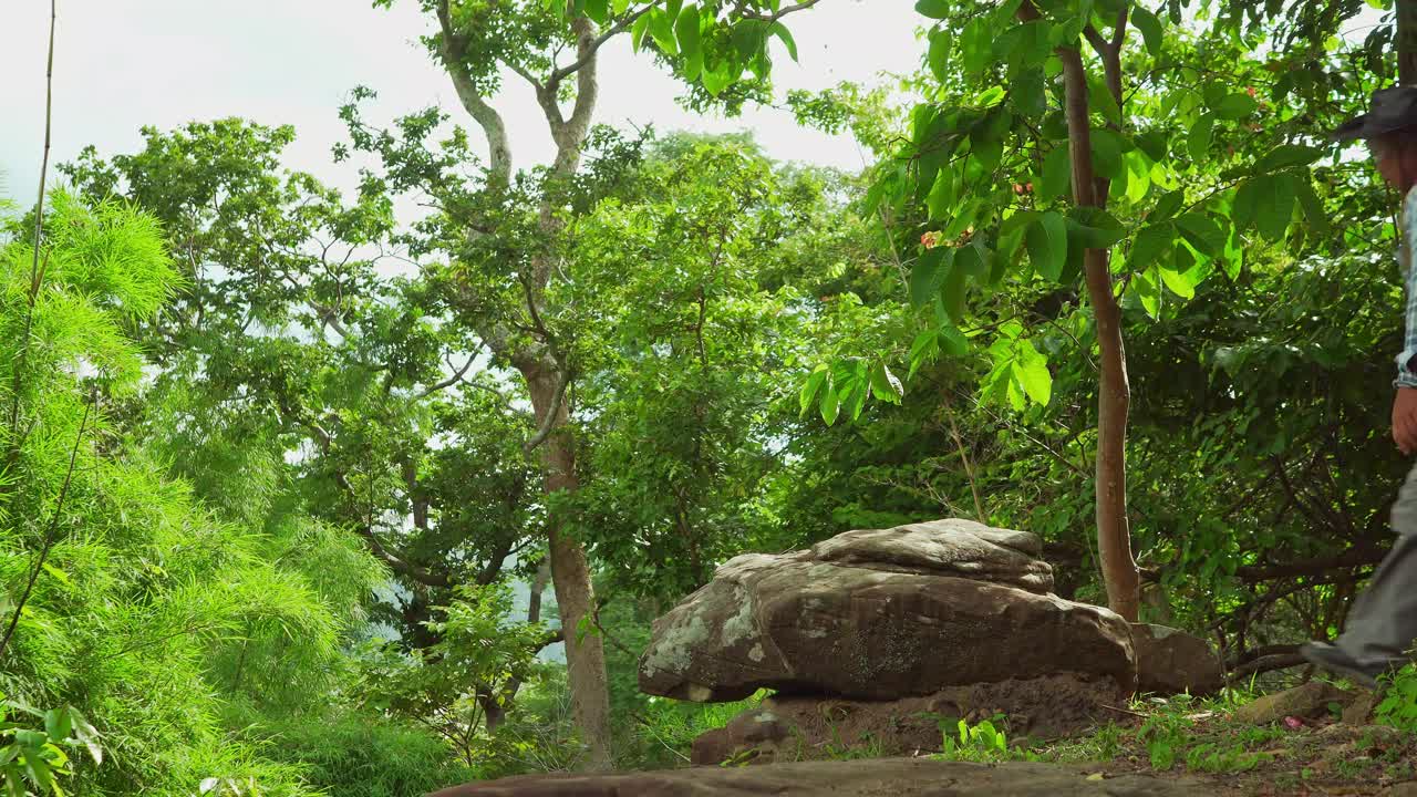 男性背包客独自旅行拿着相机自然森林山攀登美丽的岩石悬崖拍照